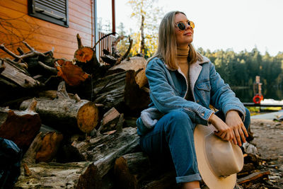 Portrait of young woman sitting on wood