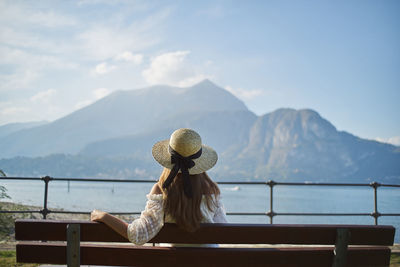 Rear view of woman looking at mountains against sky