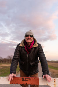 Middle aged man wearing winter clothes taking a break in a country road - people in recreation