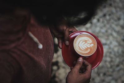 Close-up of hand holding coffee cup