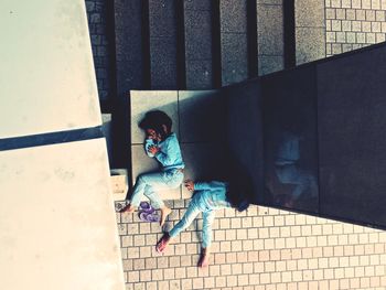 High angle view of girl sitting on staircase