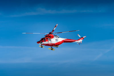 Low angle view of helicopter flying in sky