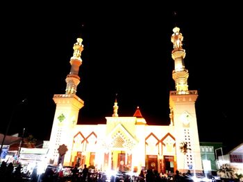 Low angle view of illuminated building against sky at night