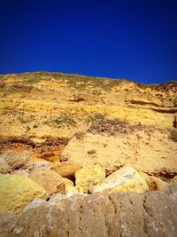 Scenic view of desert against blue sky