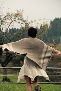 Rear view of woman standing on field