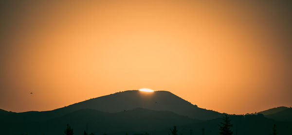 Scenic view of silhouette mountains against sky during sunset