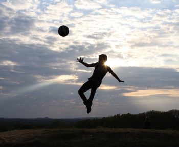 Low angle view of man playing with ball against sky