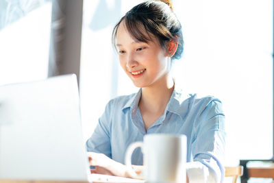 Young woman using laptop at table