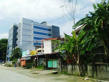 Buildings by street against sky in city