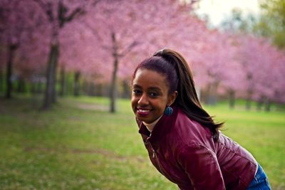 Portrait of smiling young woman on pink land