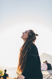 Side view of woman standing against clear sky