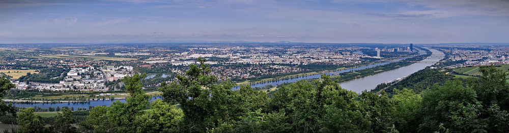 High angle view of cityscape by river against sky