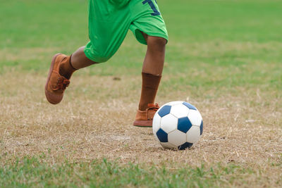 Low section of man playing soccer on field