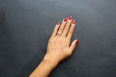 Close-up of woman hand against colored background