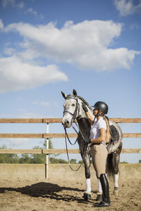 Side view of woman stroking horse