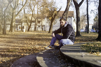 Woman sitting on sidewalk in park