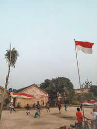 Group of people on street against clear sky