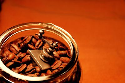 High angle view of coffee beans and grinder in container