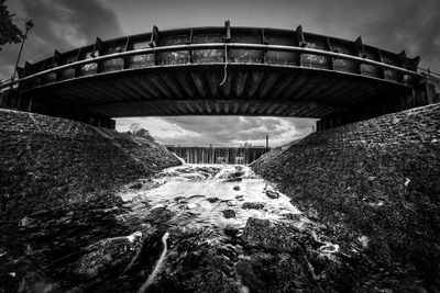 Low angle view of bridge over river against sky