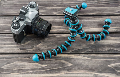 High angle view of old camera with tripod on table