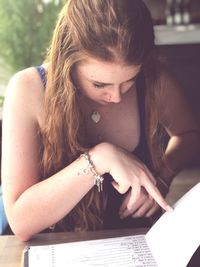 Young woman reading menu at restaurant