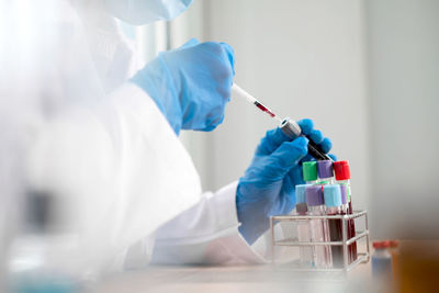 Midsection of scientist doing experiment on table