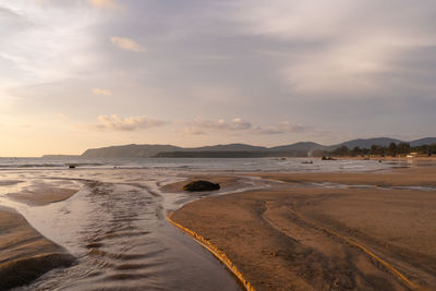 Scenic view of beach against sky during sunset