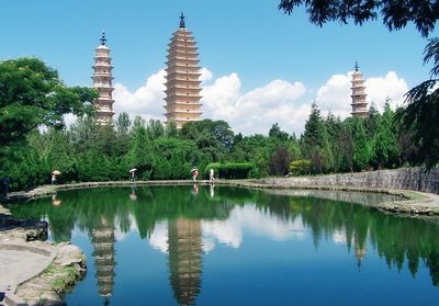 Reflection of temple on water against sky