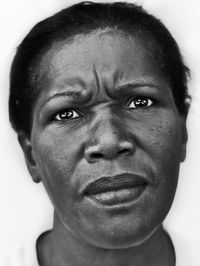 Close-up portrait of woman against white background