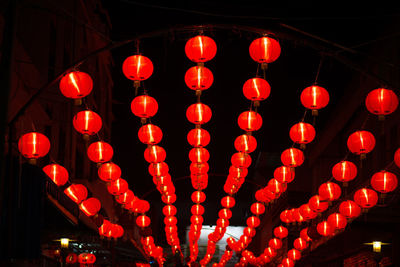 Low angle view of illuminated lanterns hanging at night