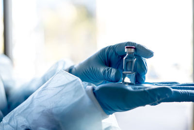 Close-up of scientists hands holding vial