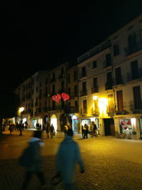 People in illuminated city at night