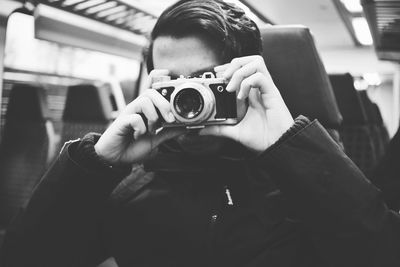 Man photographing while sitting in train