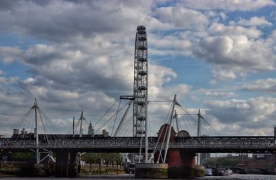 Suspension bridge against cloudy sky