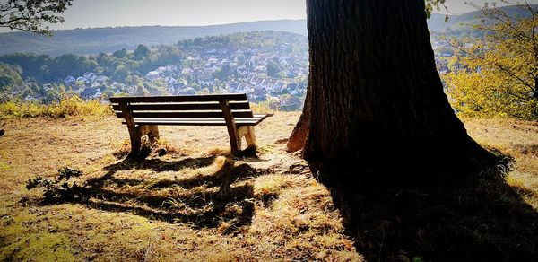 Bench in park against mountains