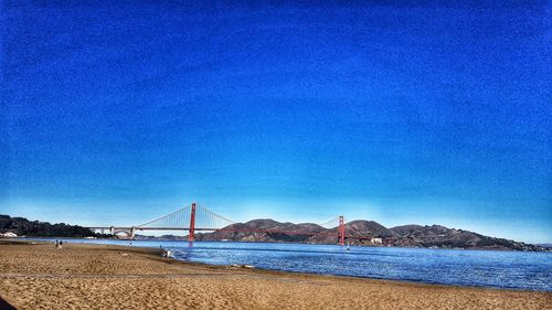 Scenic view of beach against clear blue sky