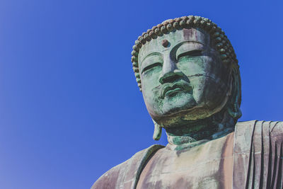 Low angle view of statue against clear blue sky