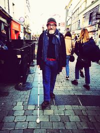 Full length portrait of man standing on footpath