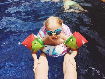 High angle view of girl swimming by leg in swimming pool