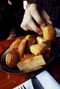 Close-up of hand holding bread on table