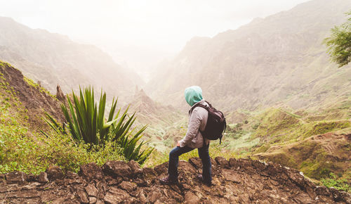 Man standing on land against mountains