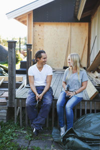 Happy couple looking at each other outside house during home improvement