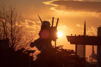 Silhouette statue against sky during sunset