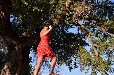 Low angle view of woman against trees