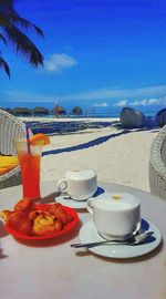 Close-up of tea served on table at beach