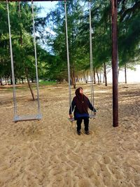 Rear view of woman on swing in playground