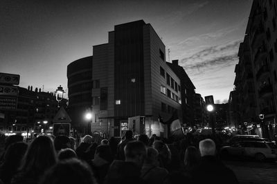 Crowd on city street amidst buildings against sky