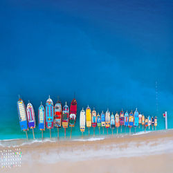 Multi colored deck chairs on beach against blue sky