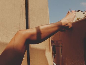 Side view of woman standing against wall