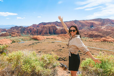 Rear view of woman standing on mountain against sky